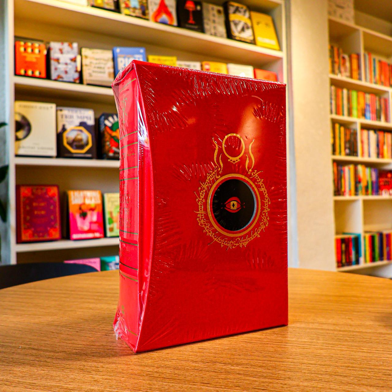 Red book with embossed design on a wooden table in a library setting